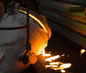 Image of metal pouring into sand castings showing